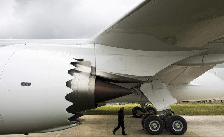 Image: A man walks beneath a Boeing 787 Dreamli